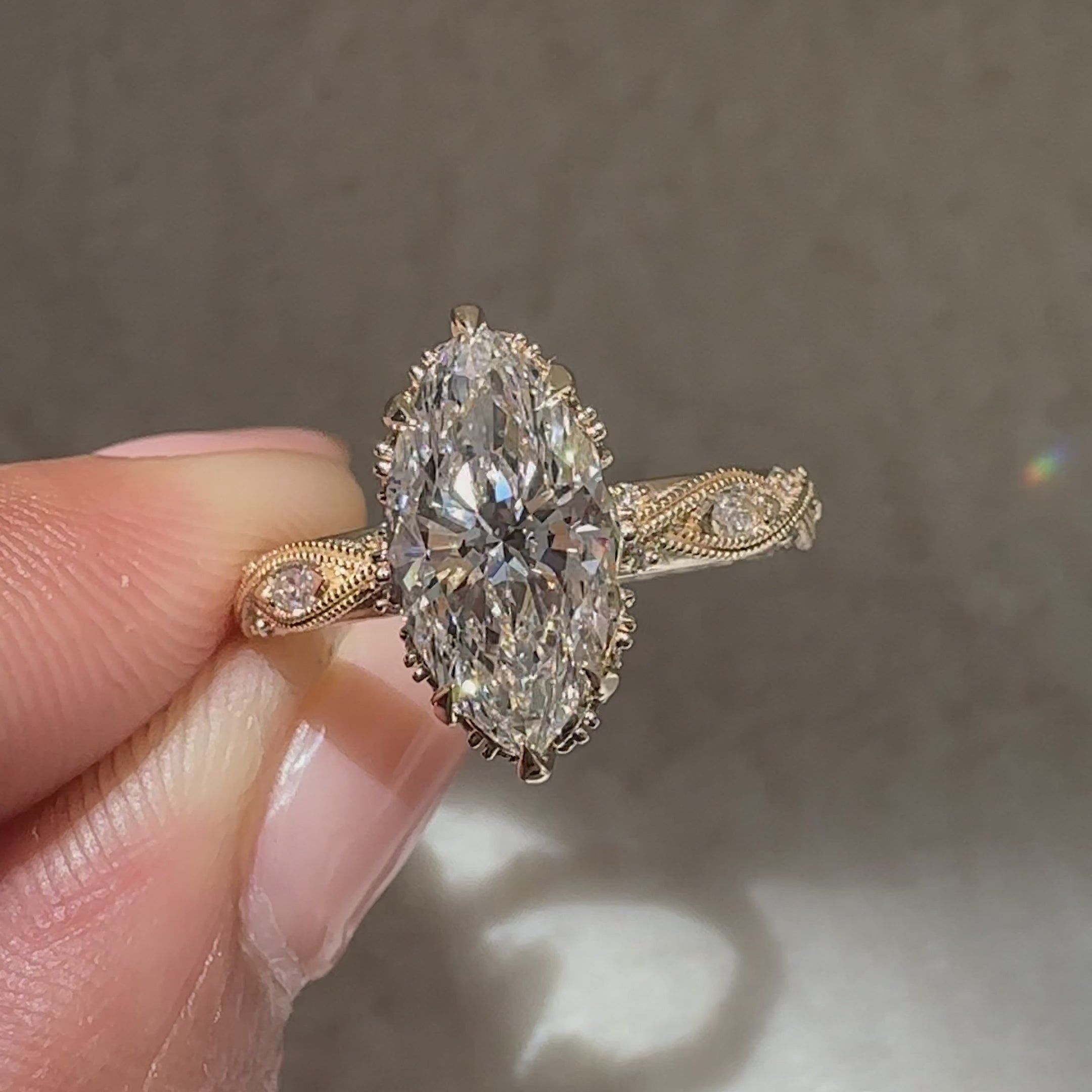 Marquise engagement ring with round side stones and hidden halo
