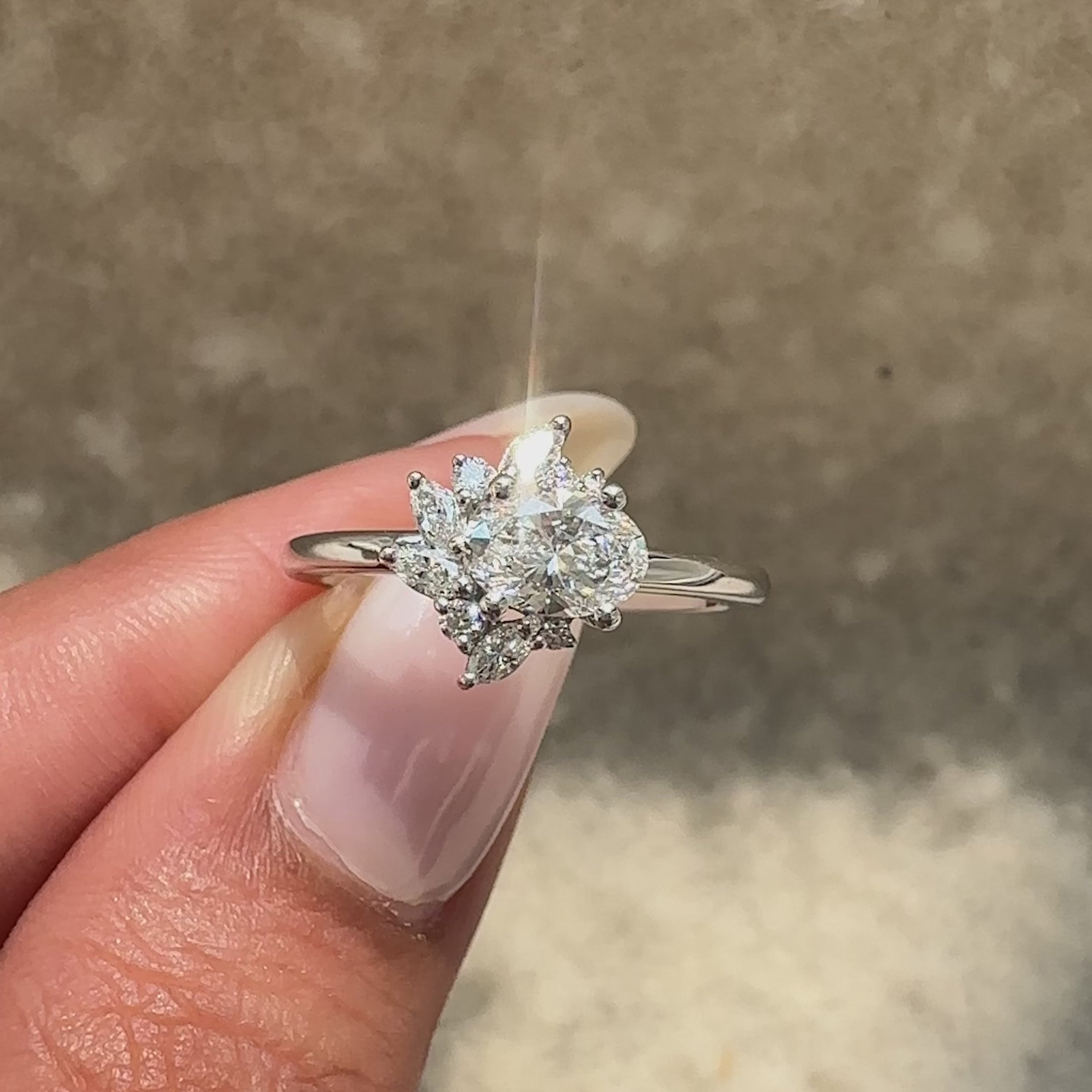 Oval diamond ring with marquise side accents.
