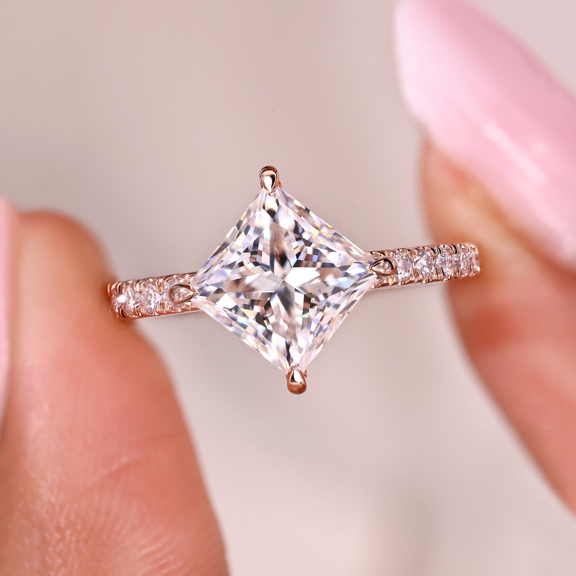 Rose gold moissanite ring with square centre stone and pave accents.