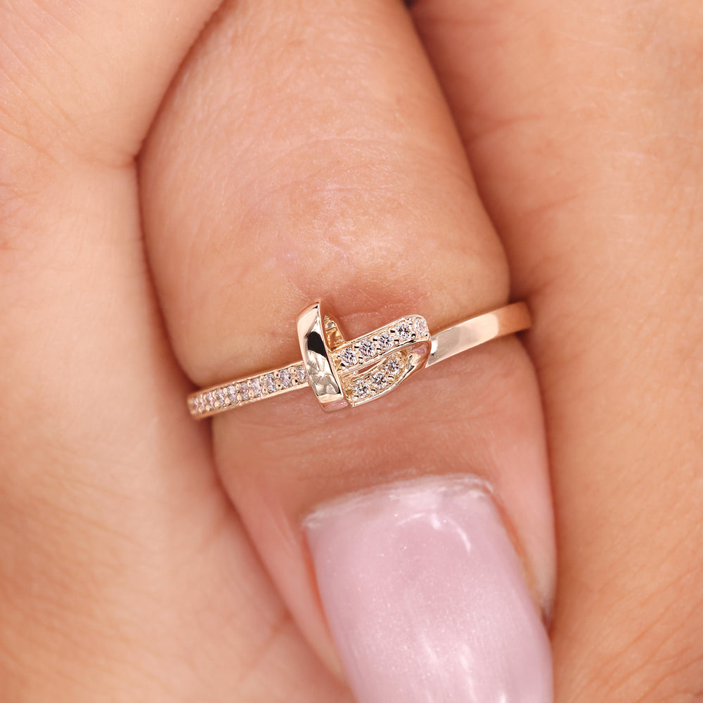 Heart shaped band made with delicate knot design and diamond accents.