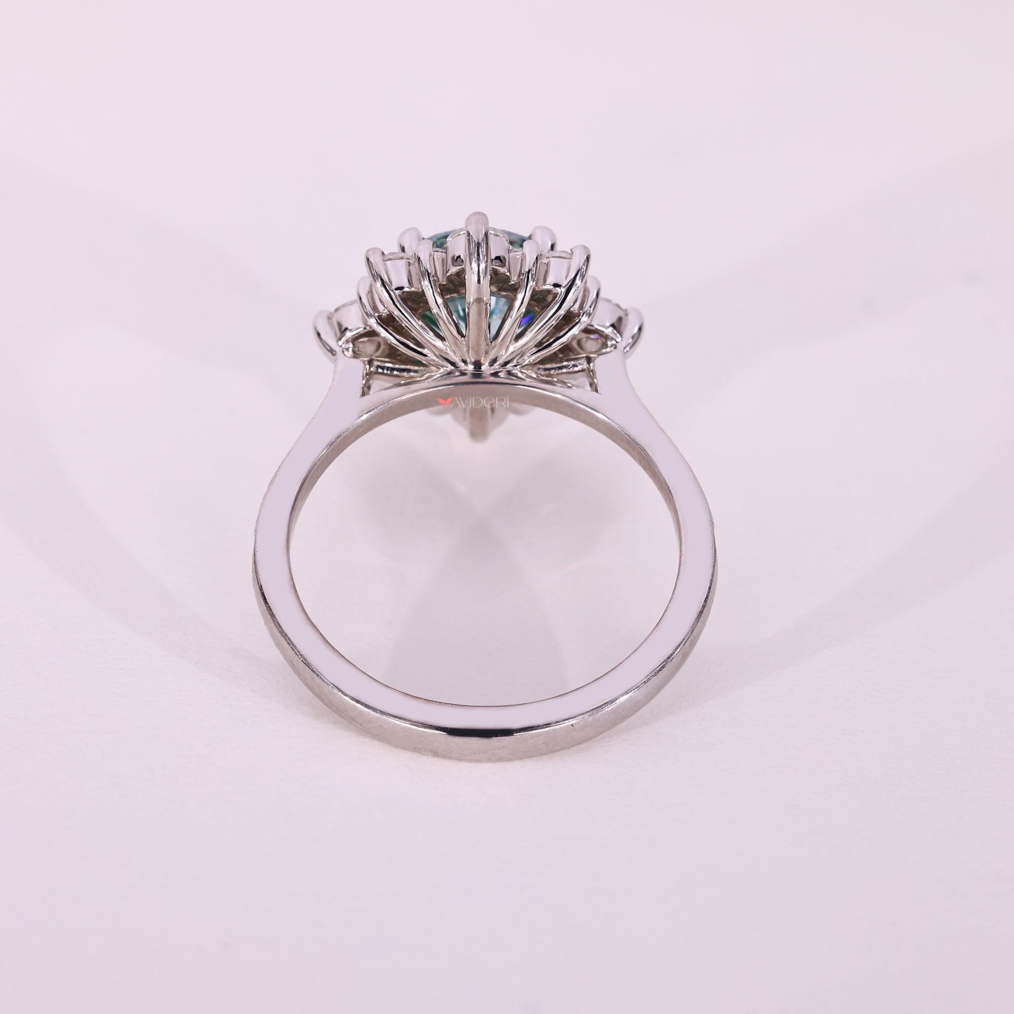 Cyan blue moissanite engagement ring with pave stones.
