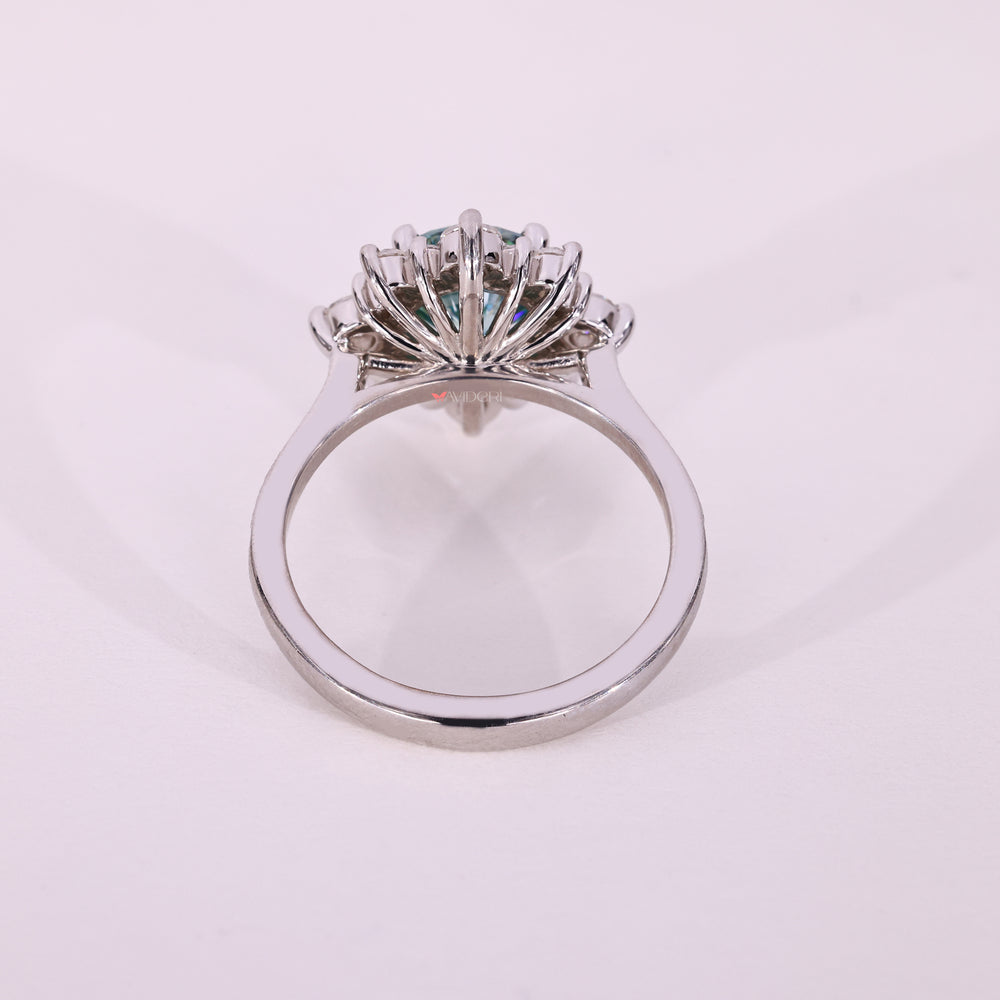 Cyan blue moissanite engagement ring with pave stones.
