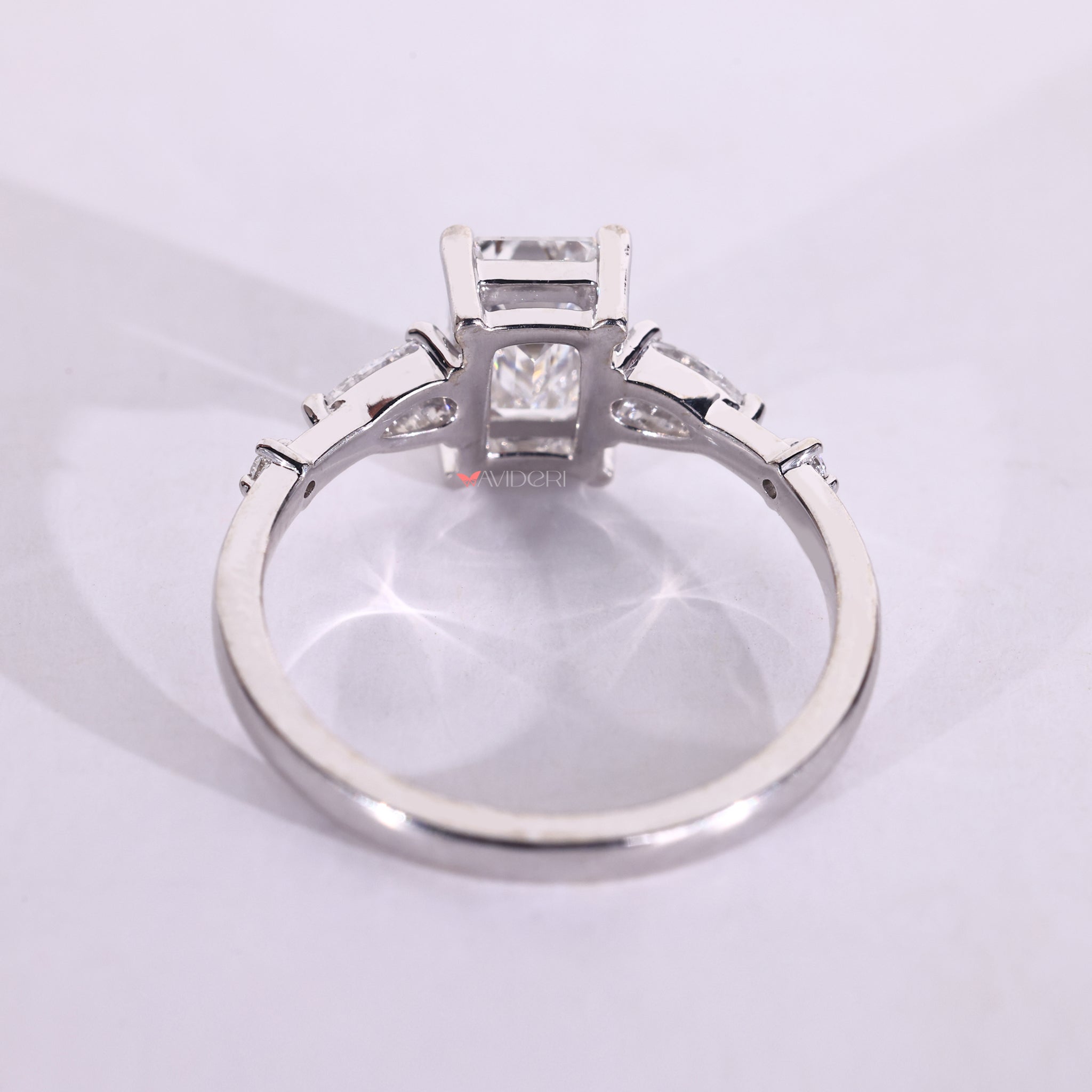 Pear and round side diamond ring set in white gold ring with handmade jewelry detail.
