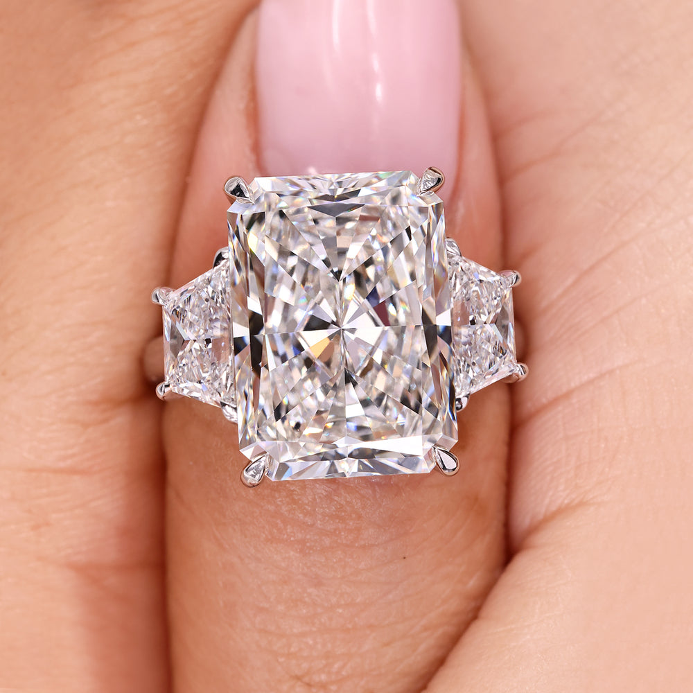 Radiant cut engagement ring with trapezoid side stone.