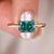 Radiant cut moissanite ring in cyan blue set in yellow gold.
