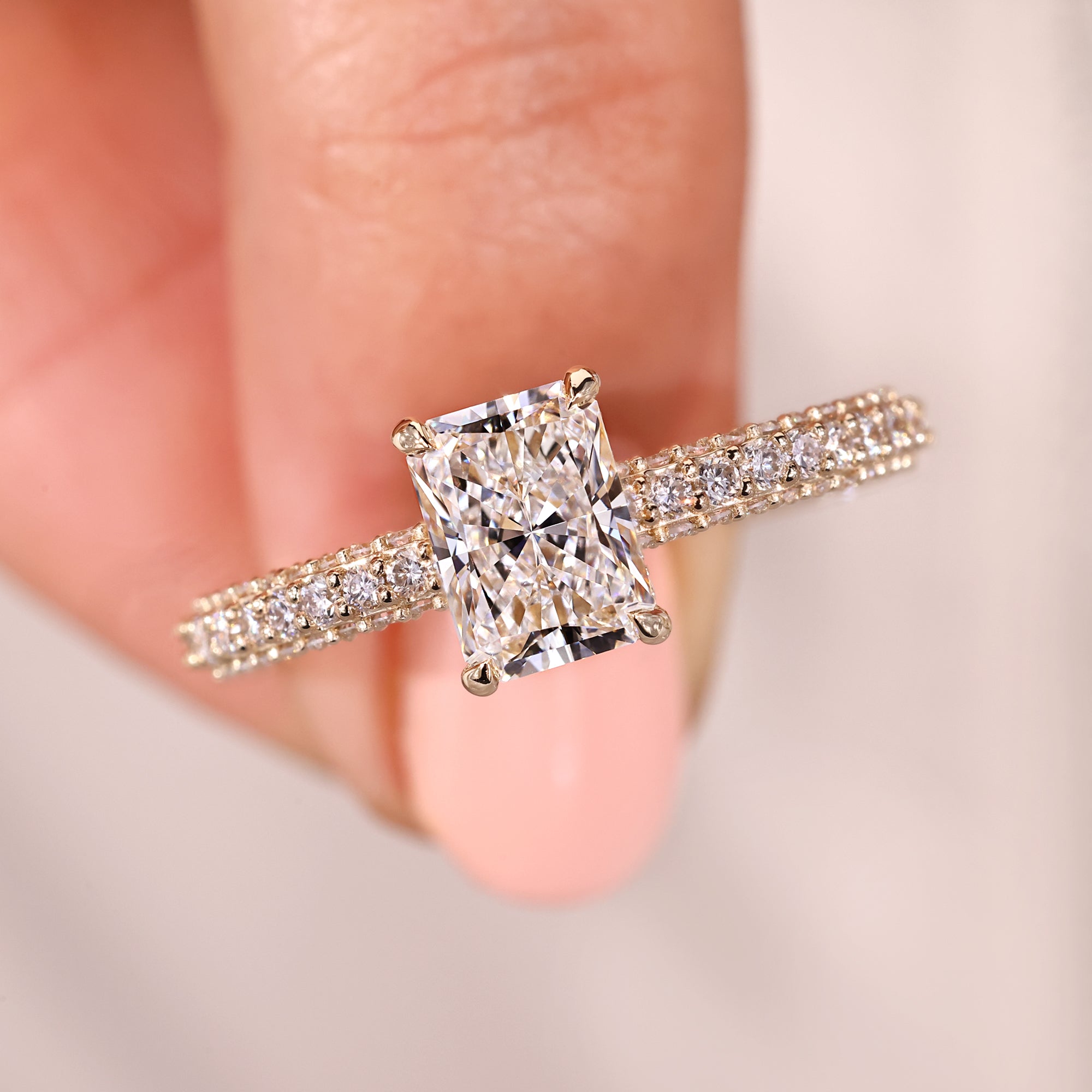 Radiant diamond engagement ring with claw prong setting.