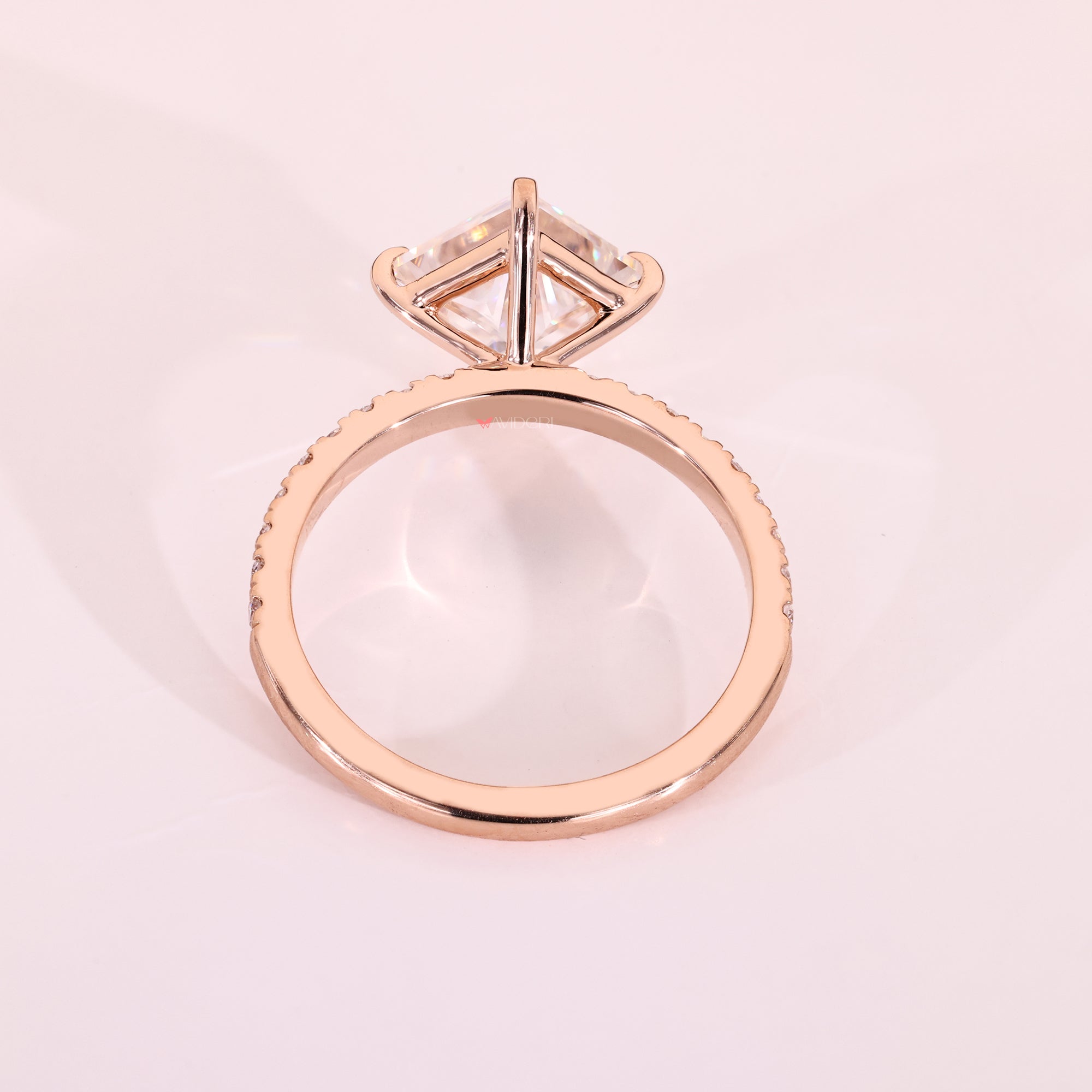 Princess cut solitaire ring accented with pave stones on a slim band.
