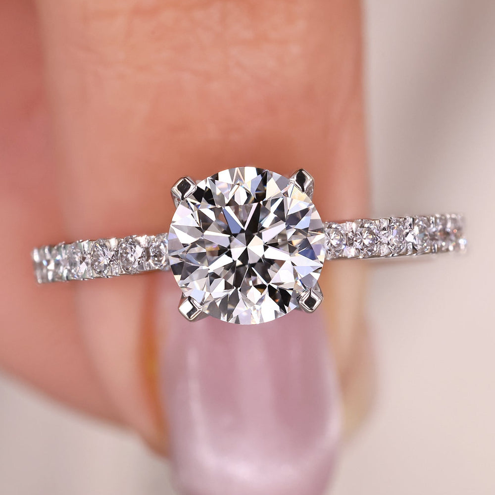 Round diamond engagement ring set in white gold with a pave setting for extra shine.
