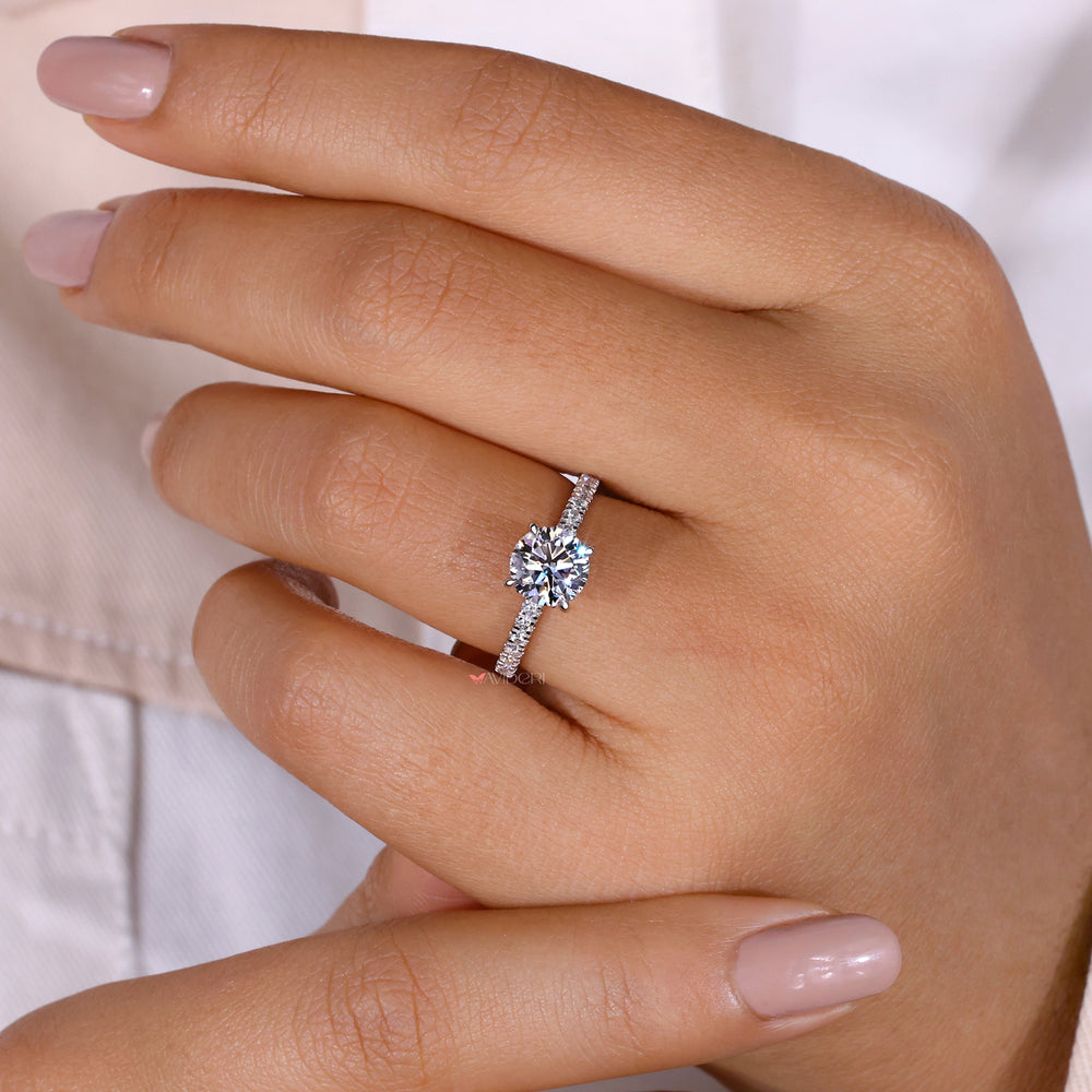 Claw prong design securely holds the round diamond in a sophisticated hidden halo setting.
