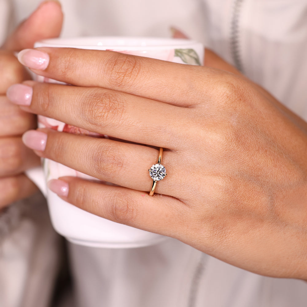 Solitaire round diamond ring with four compass claw prongs.
