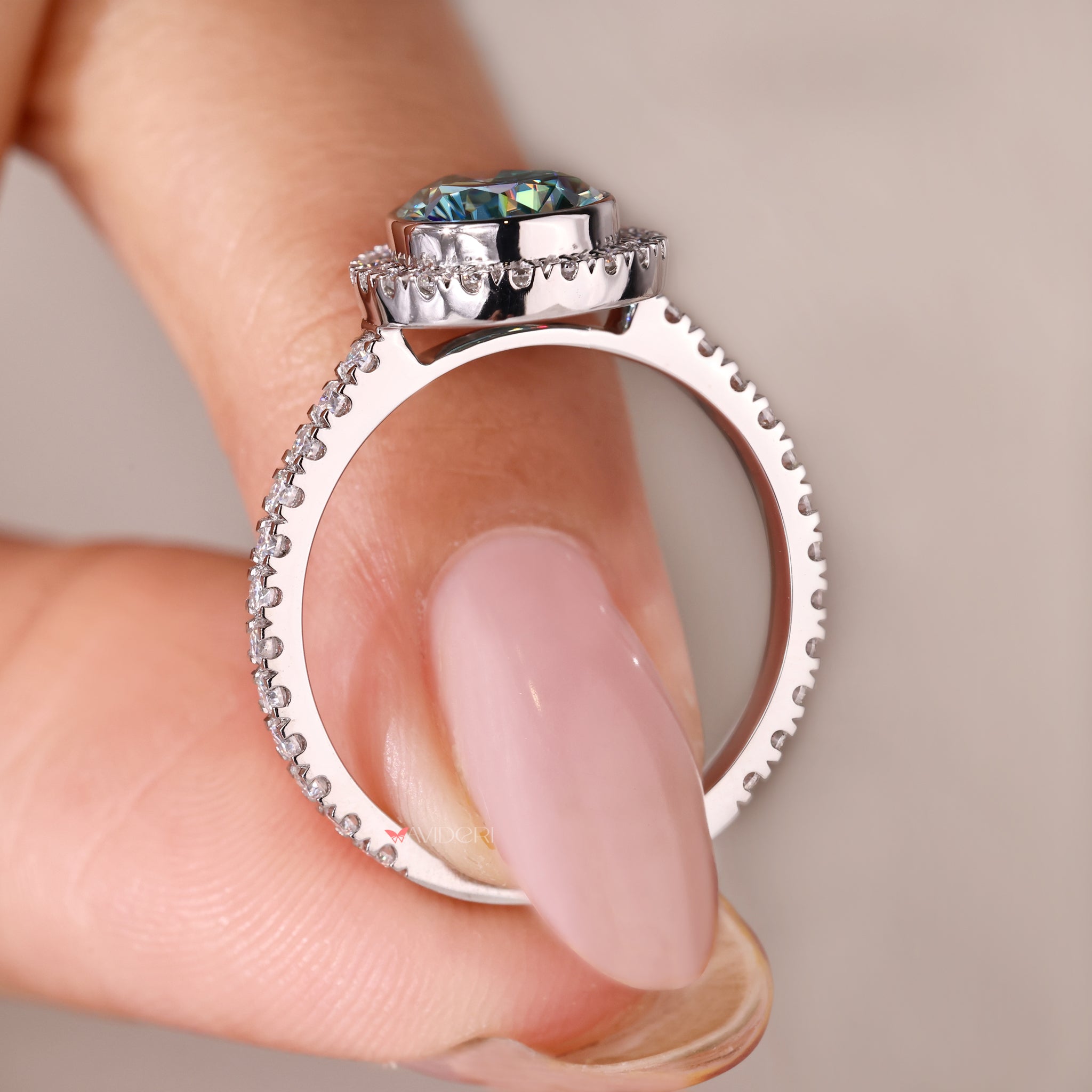 White gold engagement ring with a pear cut stone in a halo setting.
