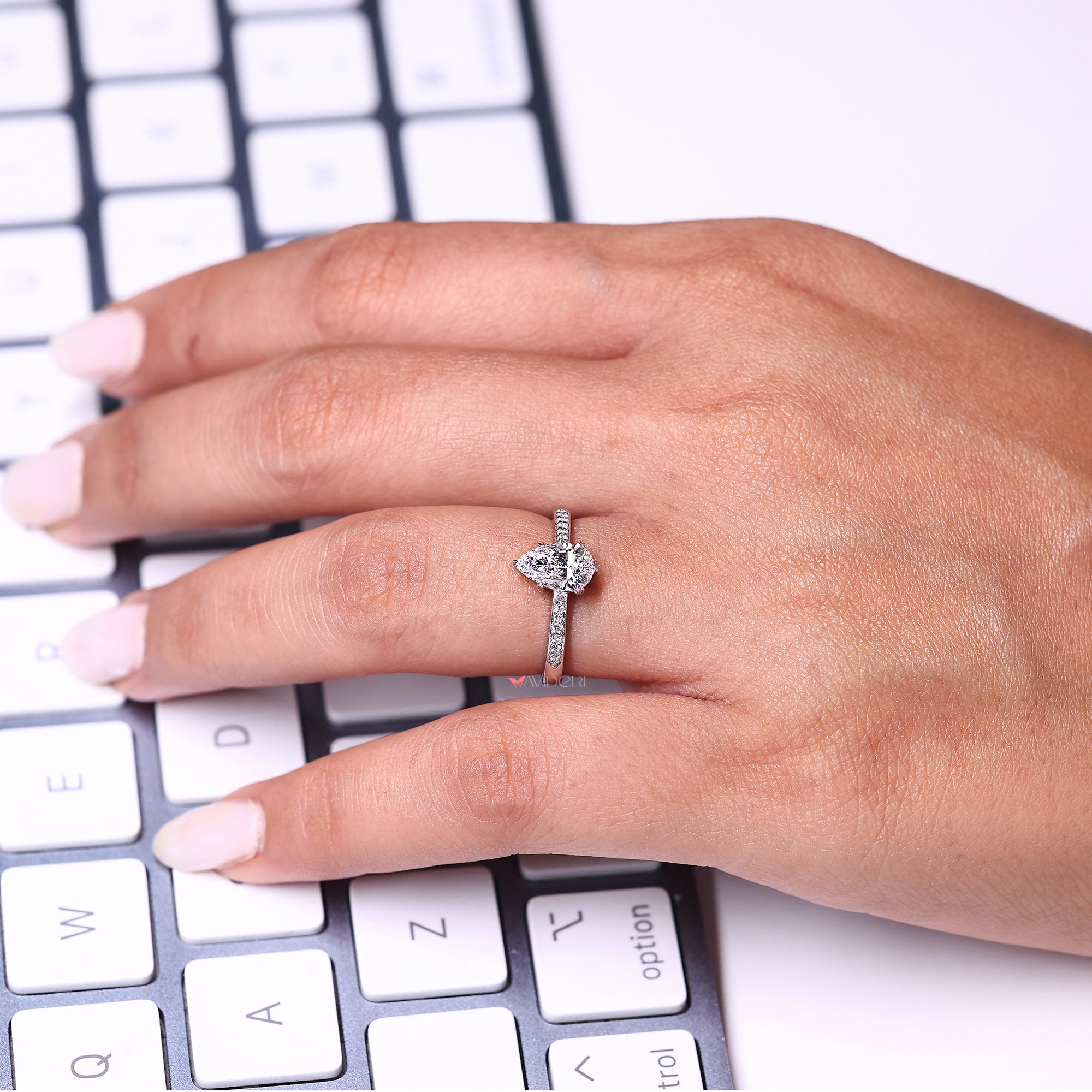 Pear and round diamond ring in white gold.
