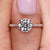 Round diamond engagement ring featuring a round diamond pave band and four claw prong setting.
