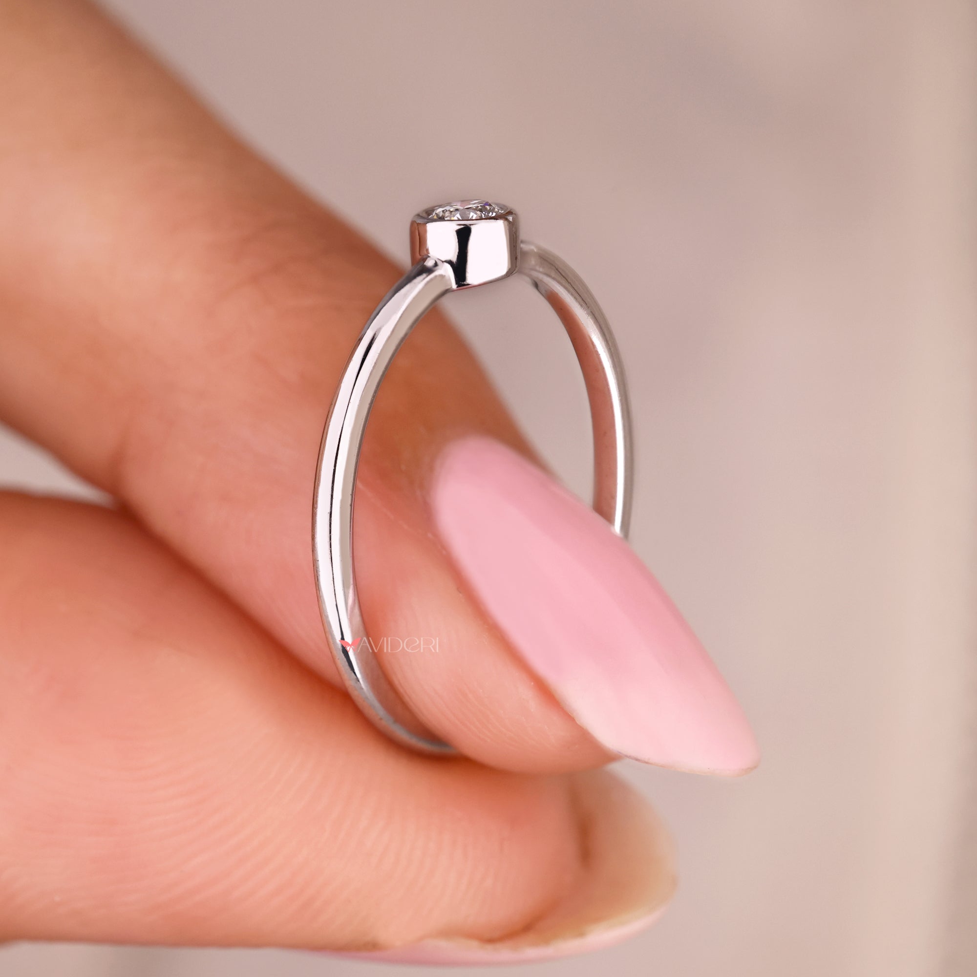 Lab grown round diamond ring in sleek bezel setting.
