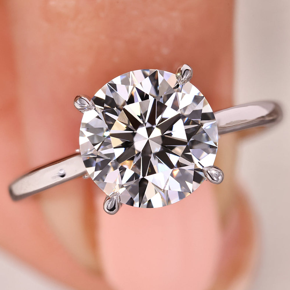 Round diamond solitaire ring with hidden halo and tapered shank