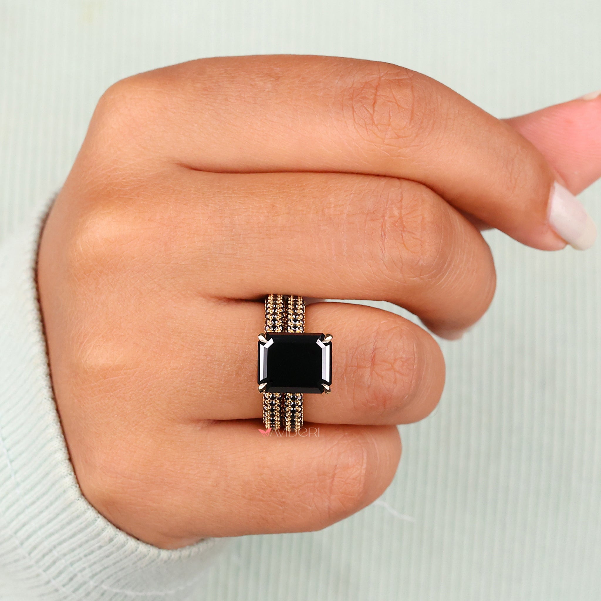 Milgrain engagement ring featuring an emerald cut moissanite center stone.

