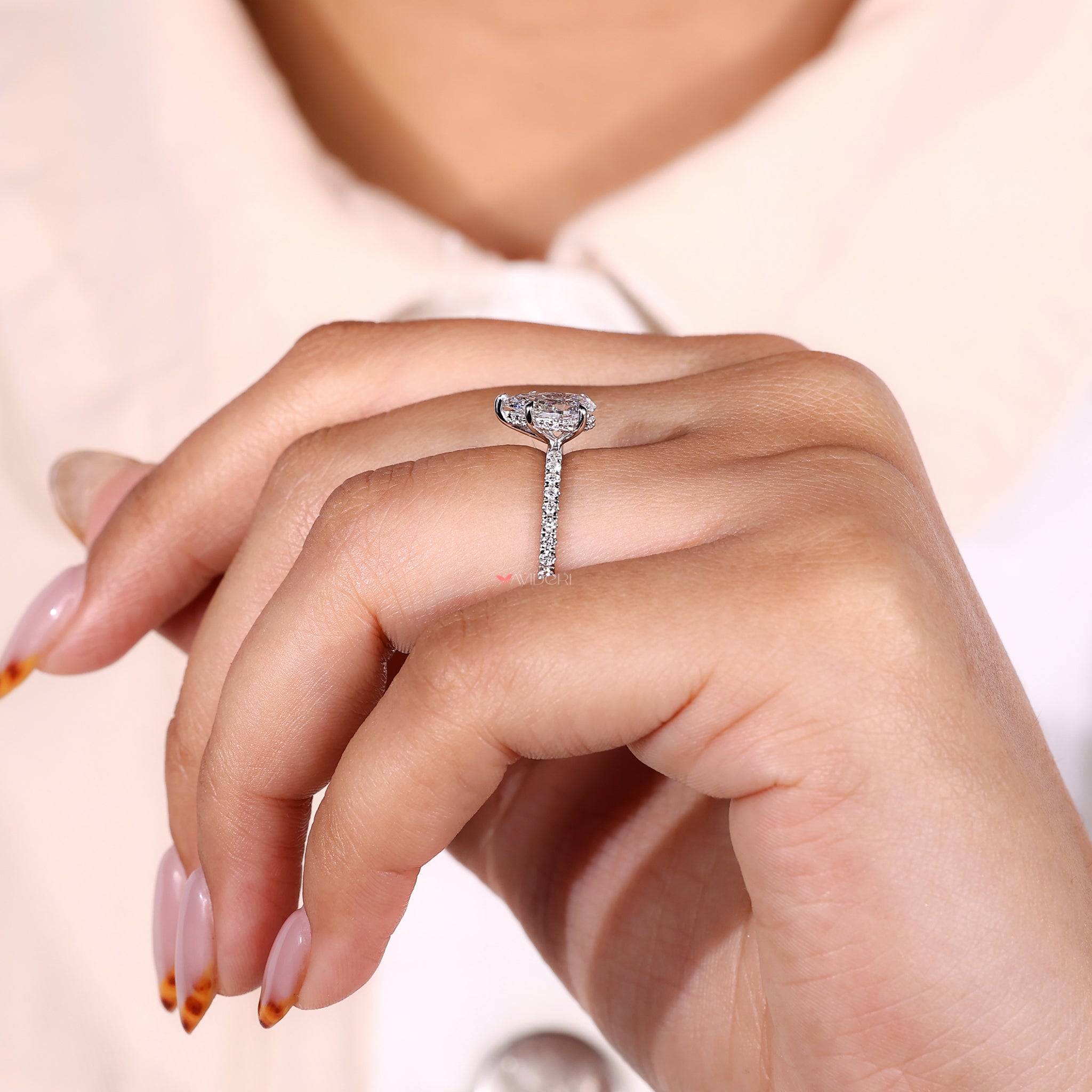 Pave Setting Ring with a pear-shaped diamond and accent stones.