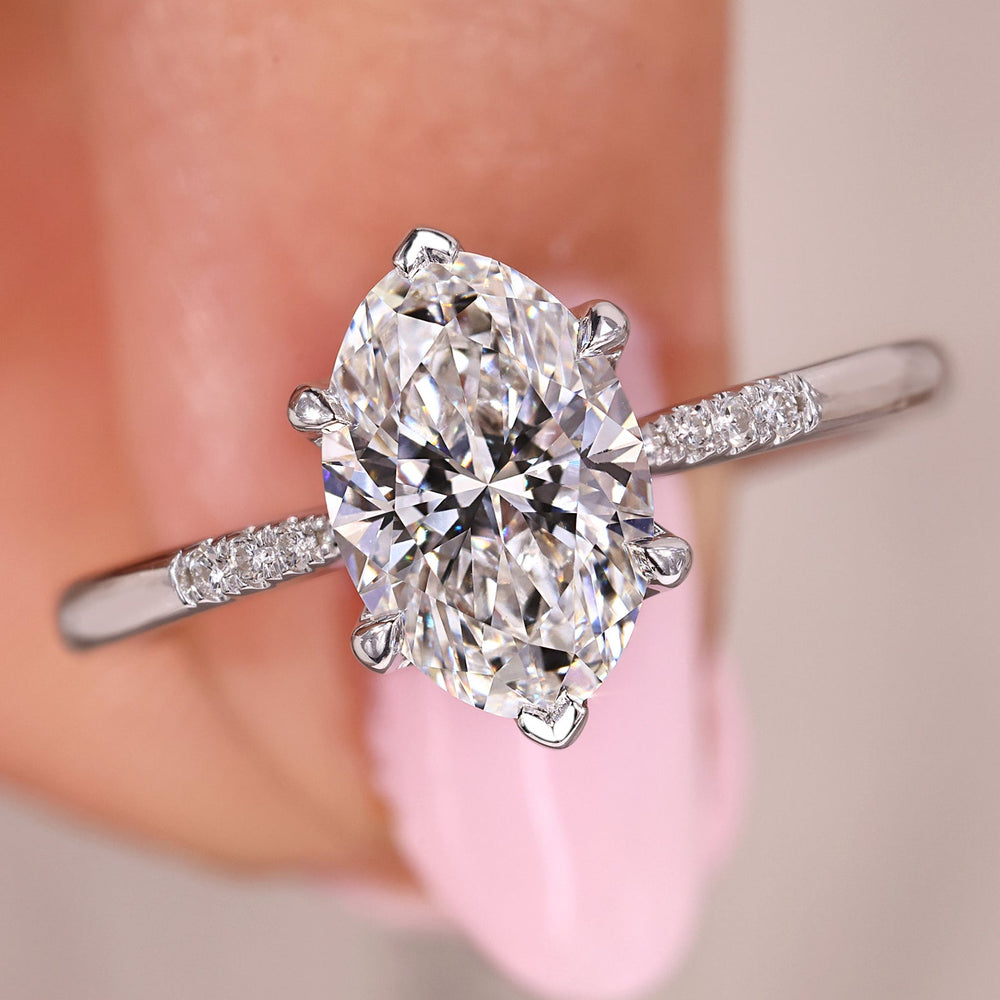 Oval diamond engagement ring with round side stones.