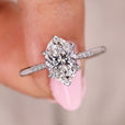 Oval diamond engagement ring with round side stones.