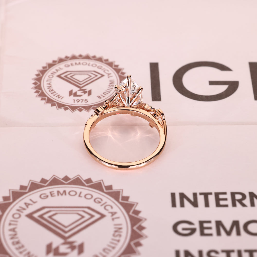 Pear diamond ring with round accents and leaf prongs
