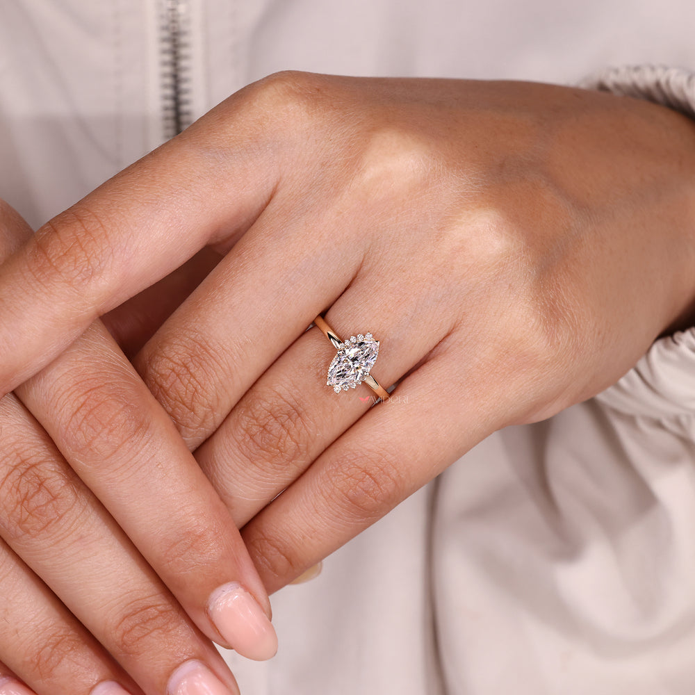 Marquise diamond ring with round diamond accents.
