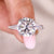 Round moissanite engagement ring with double claw prongs.
