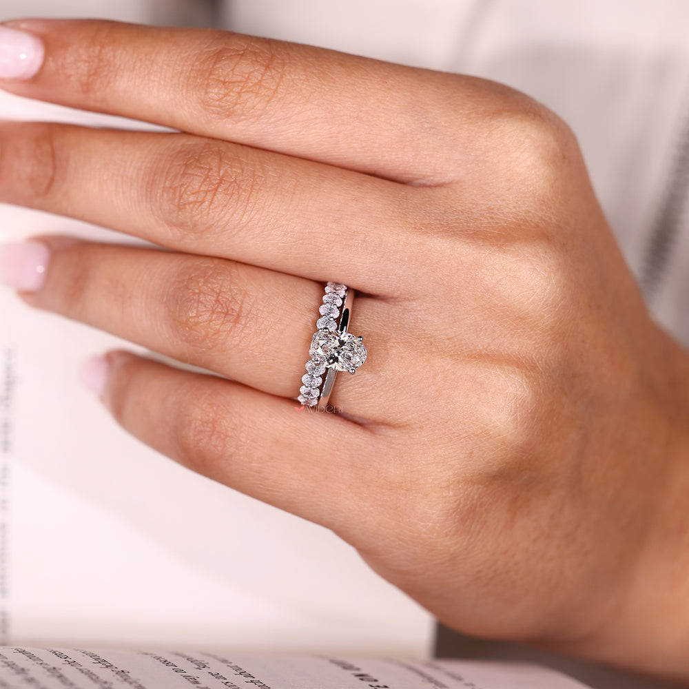 Diamond engagement ring with matching oval band.
