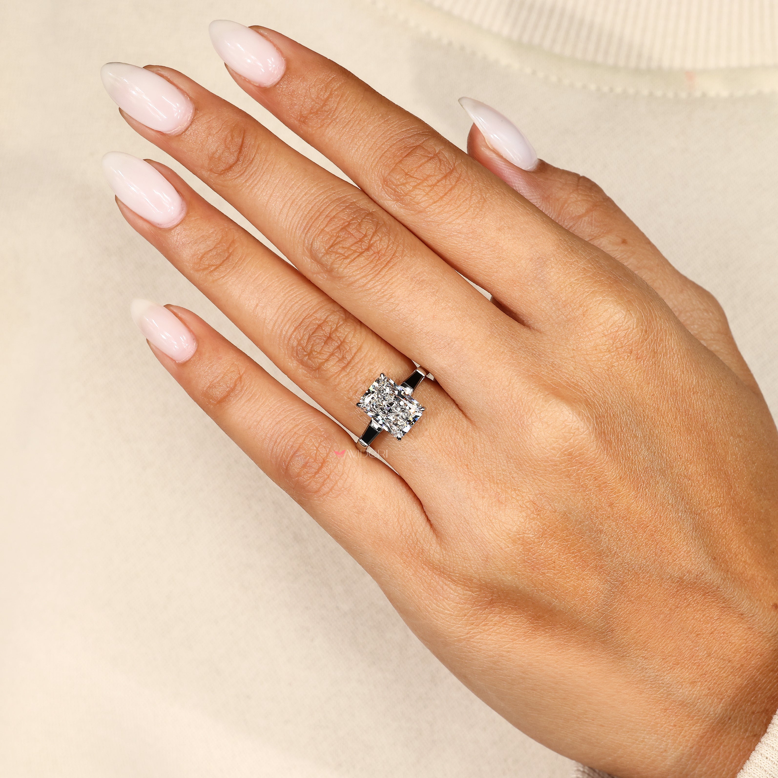 Radiant diamond ring with black baguette side stones.

