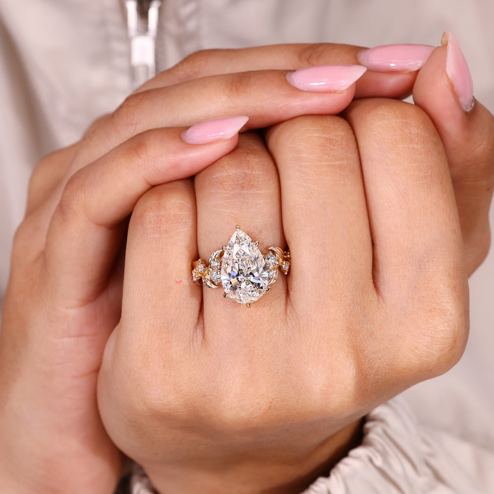 Nature inspired pear cut diamond ring with cluster sparkle.
