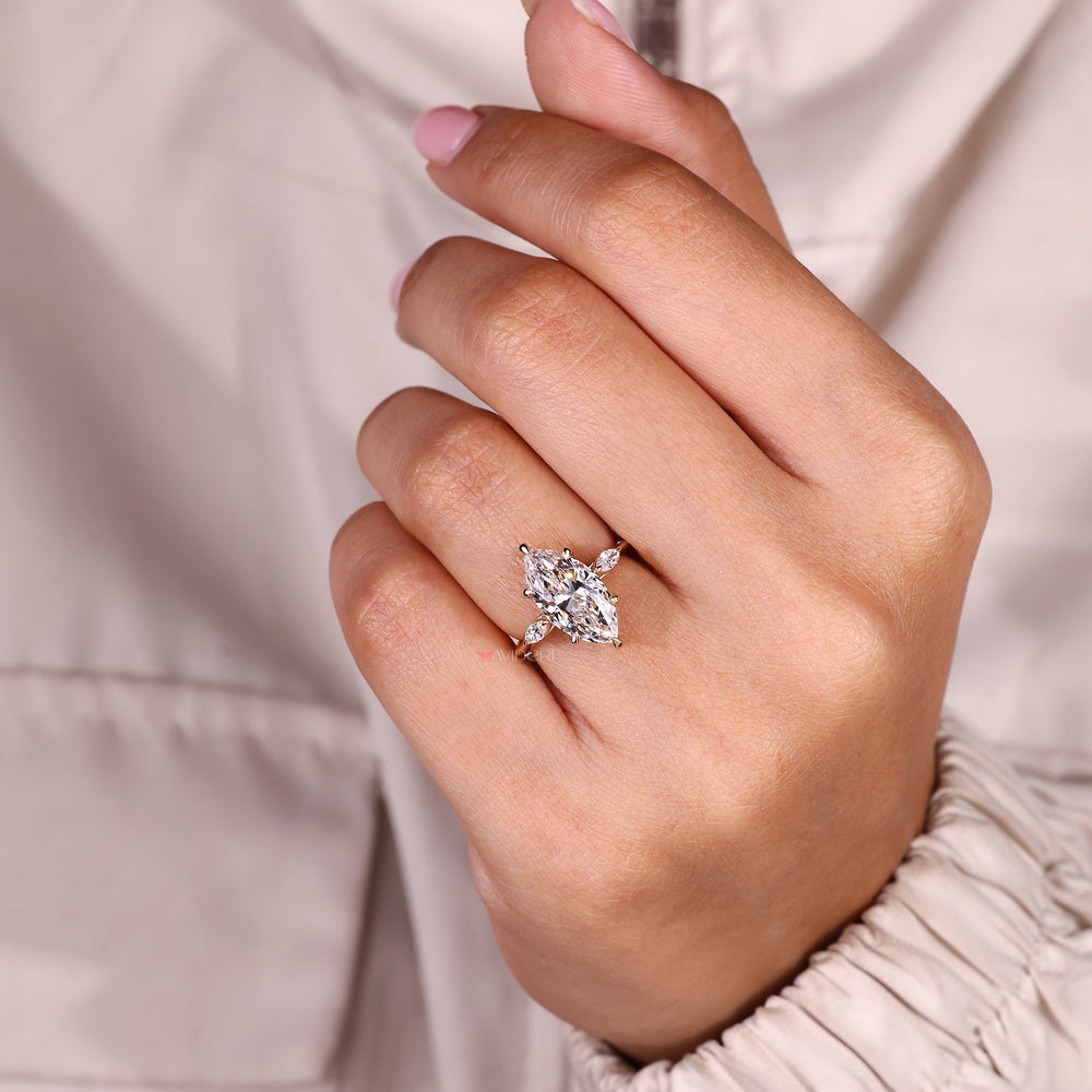 Three stone diamond ring with elegant side marquise diamonds.
