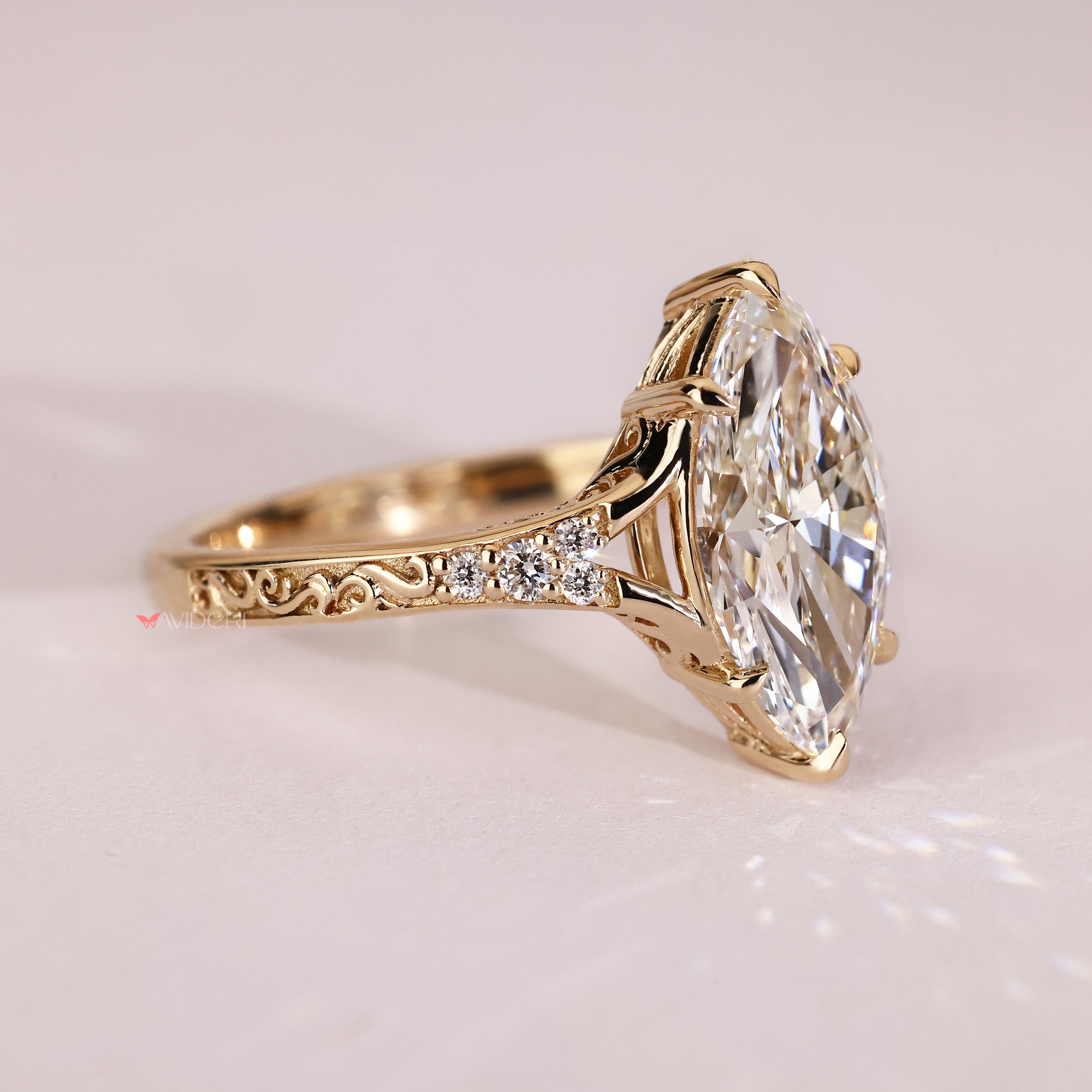 Marquise diamond ring with round accent stones and prongs
