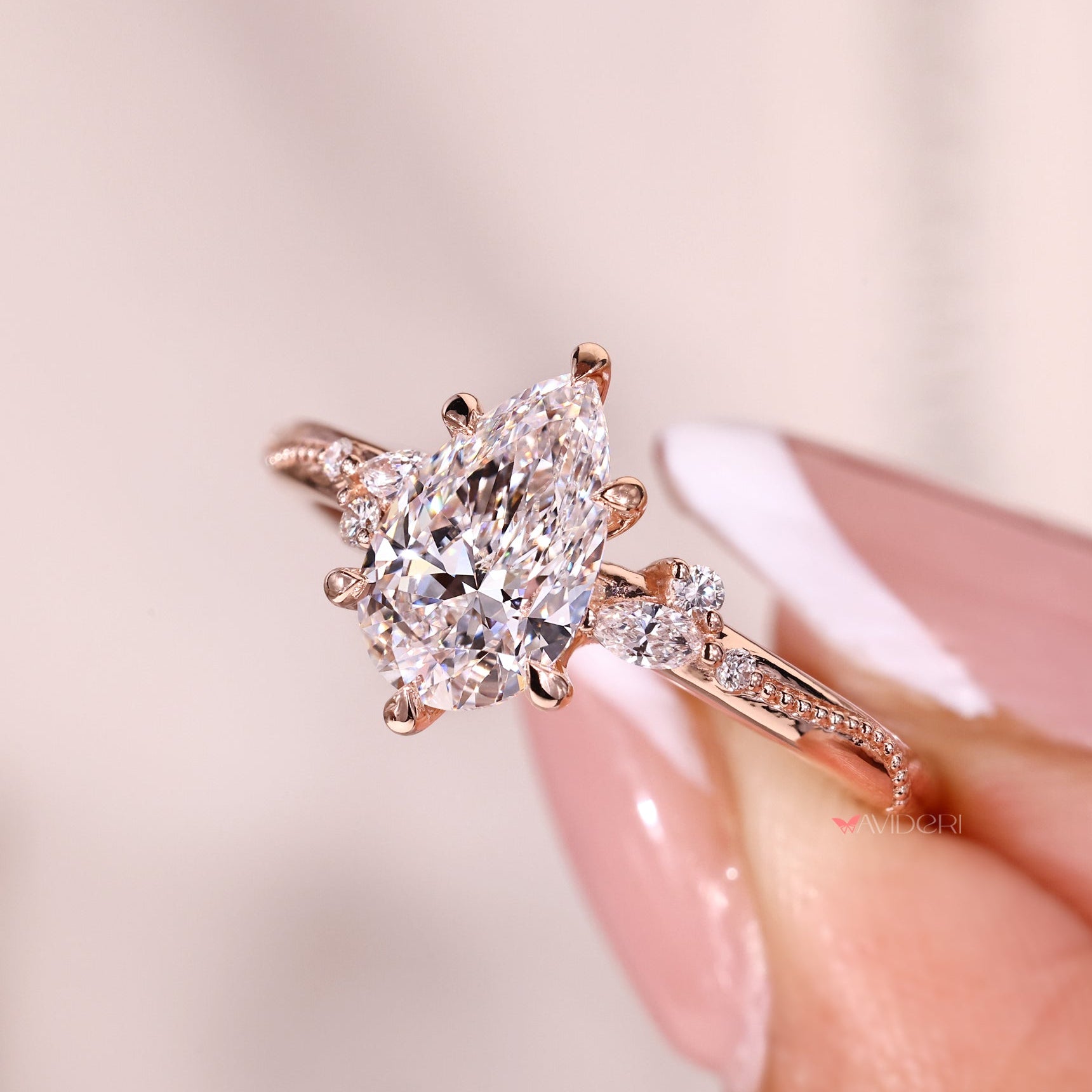 Six claw prong on marquise and round side stone.