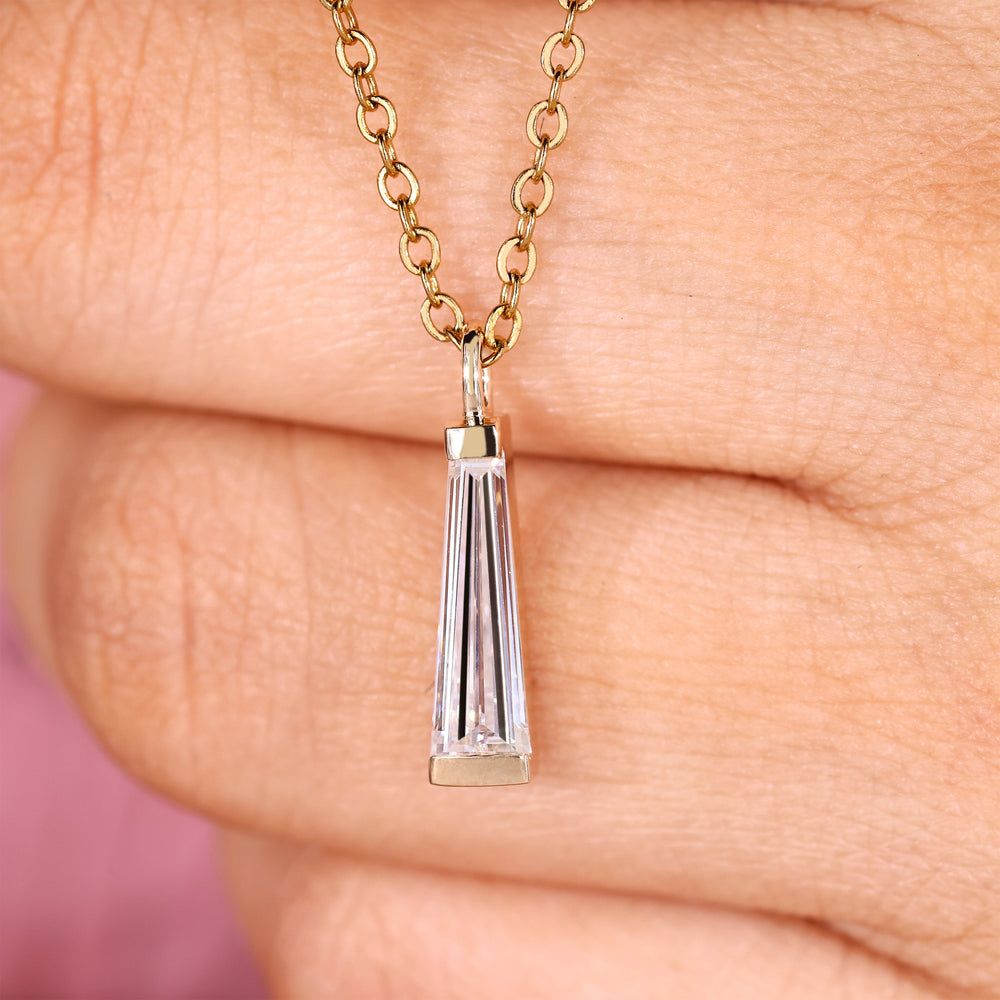 Moissanite solitaire pendant with tapered baguette cut stones.
