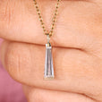 Moissanite solitaire pendant with tapered baguette cut stones.
