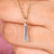Moissanite solitaire pendant with tapered baguette cut stones.
