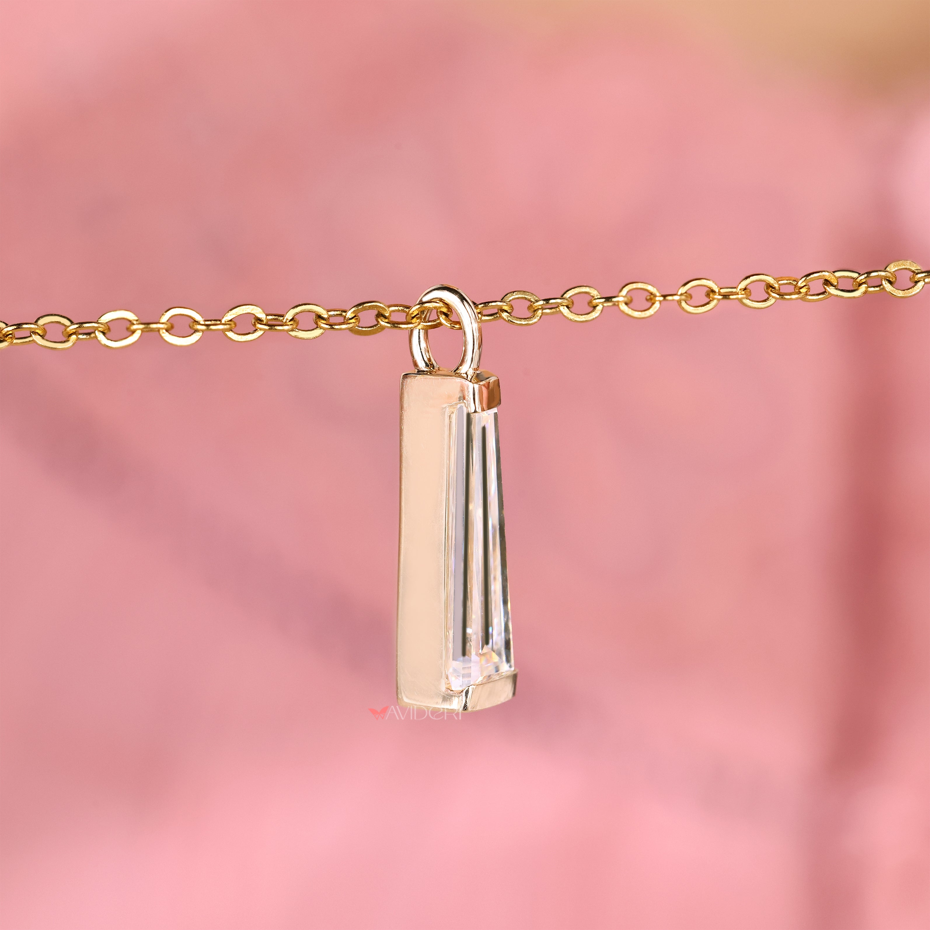 Moissanite pendant featuring tapered baguette cut side details.
