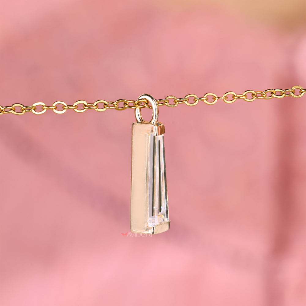 Moissanite pendant featuring tapered baguette cut side details.
