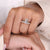 Double prong engagement ring securing the emerald cut moissanite with balance.