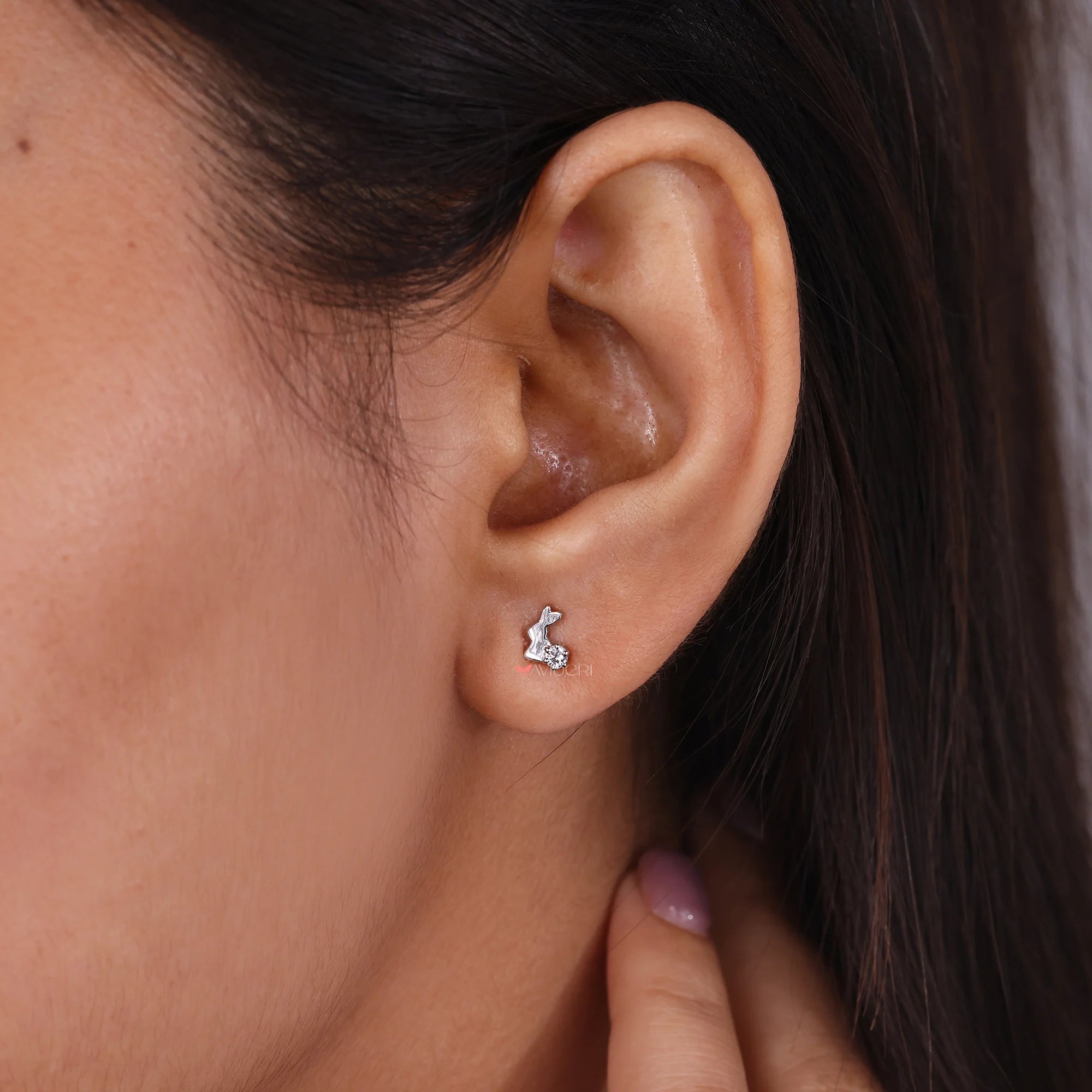 Round diamond stud earrings set in handmade jewelry design.