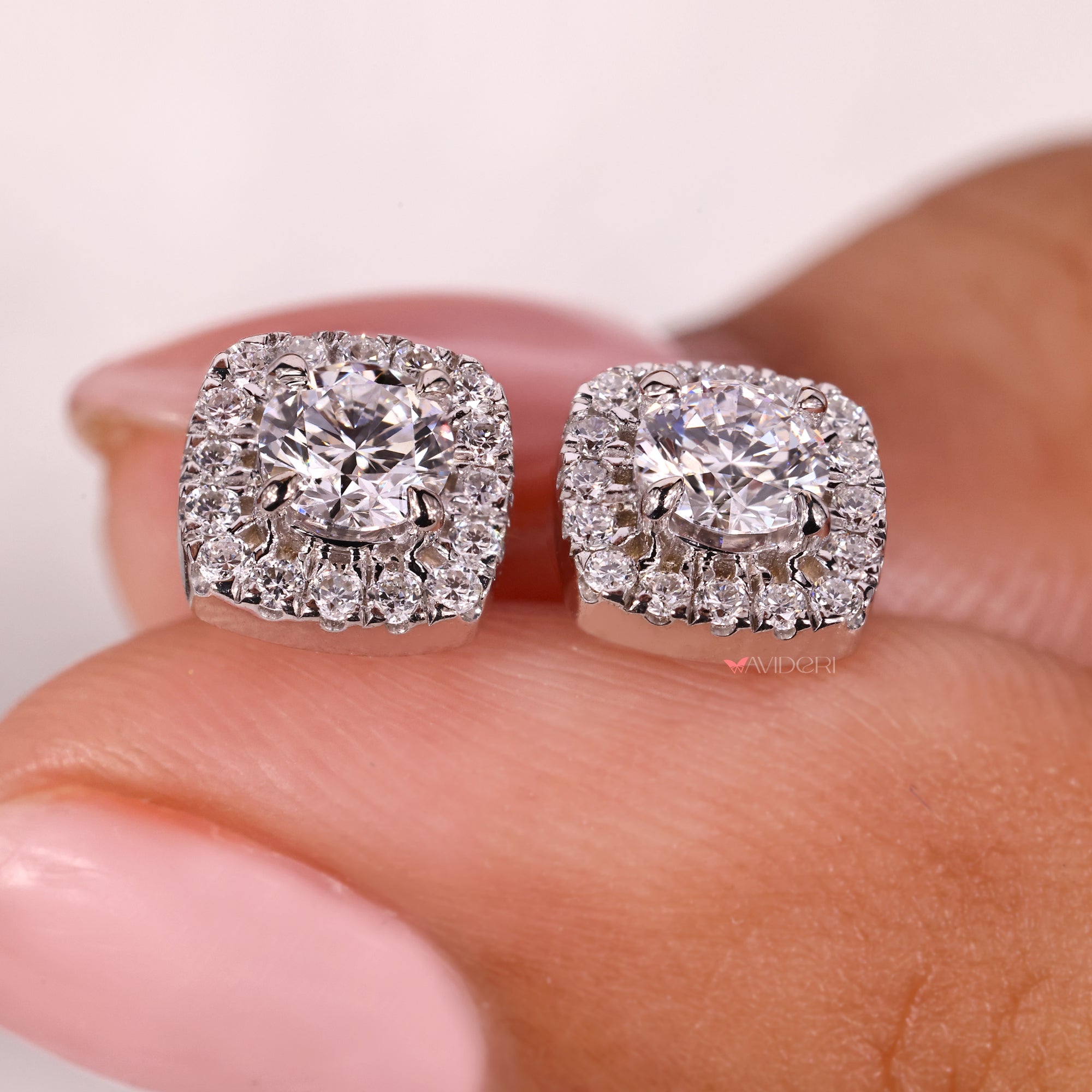Halo diamond earrings with round center stones.