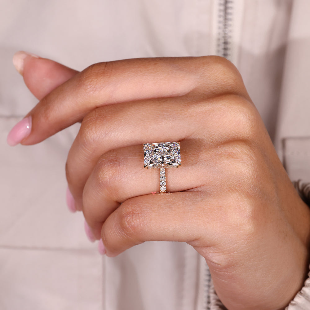 Radiant cut diamond ring with tapered shank design.
