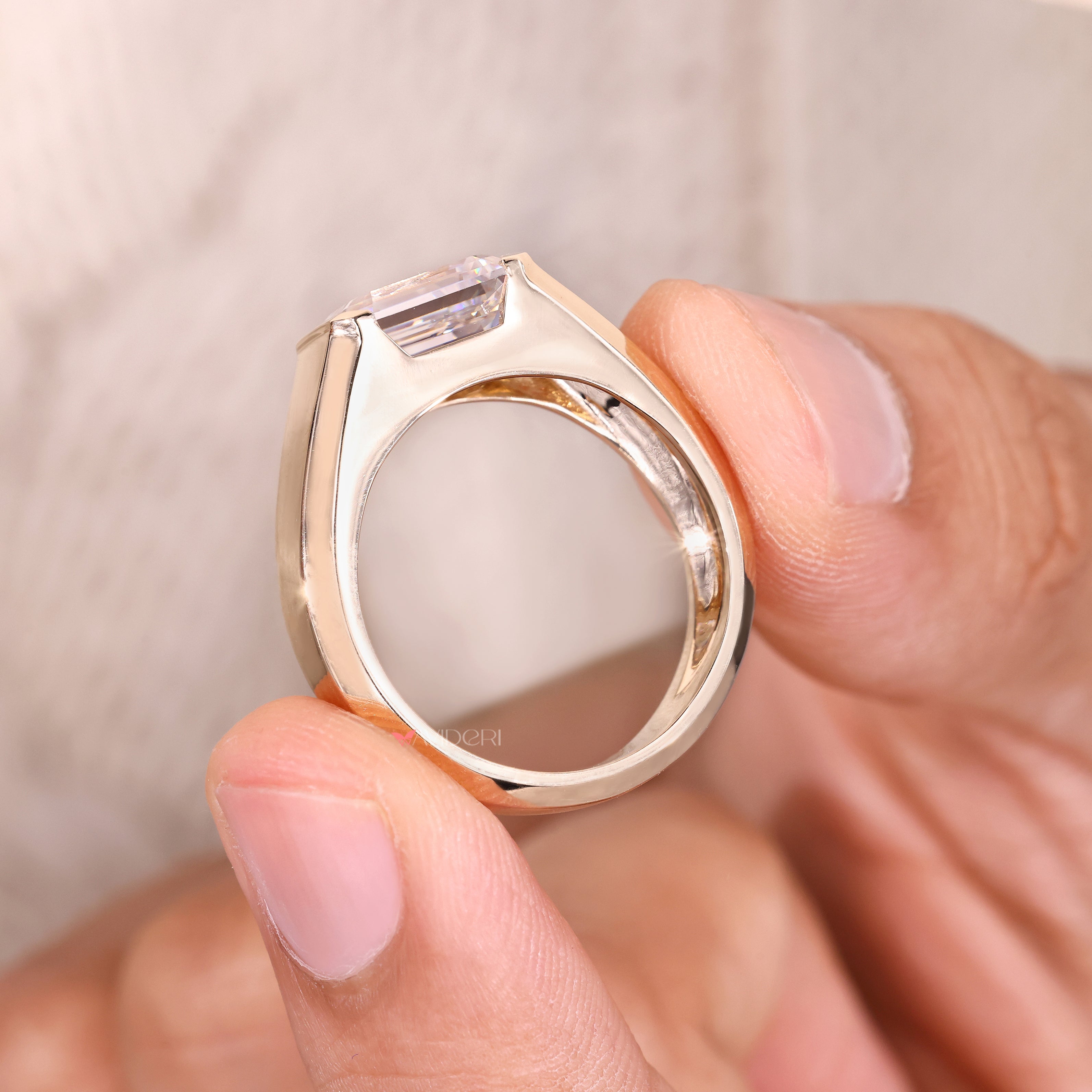 Emerald moissanite ring with bezel setting.
