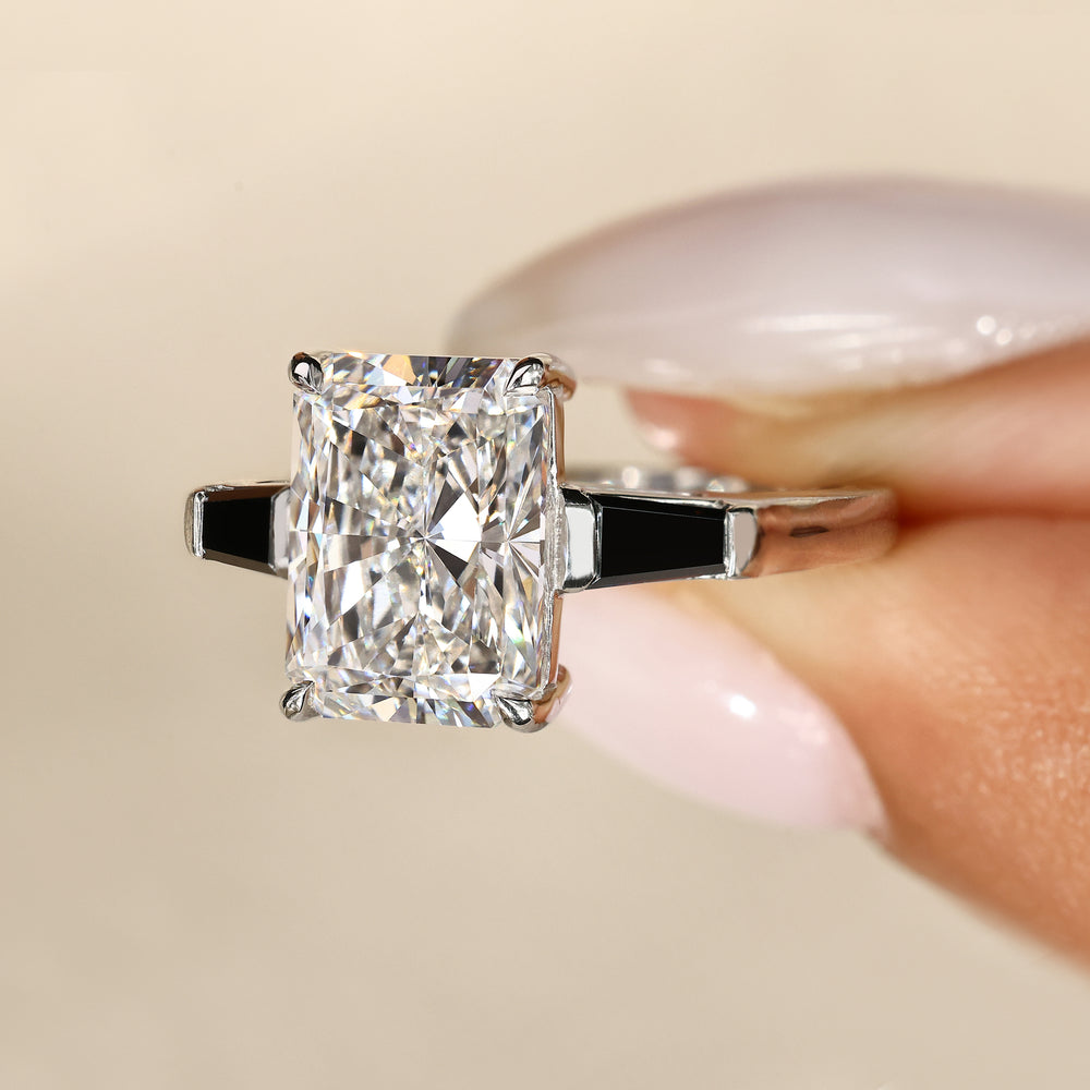 Three stone radiant diamond ring with black sides.
