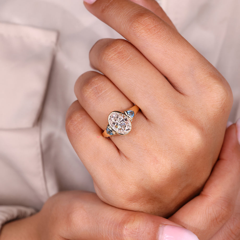 Three stone diamond ring with oval center stone.