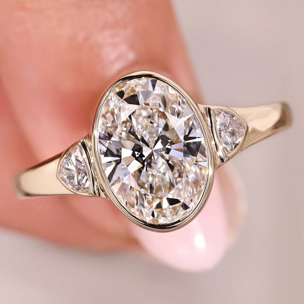 three stone bezel set diamond ring on finger