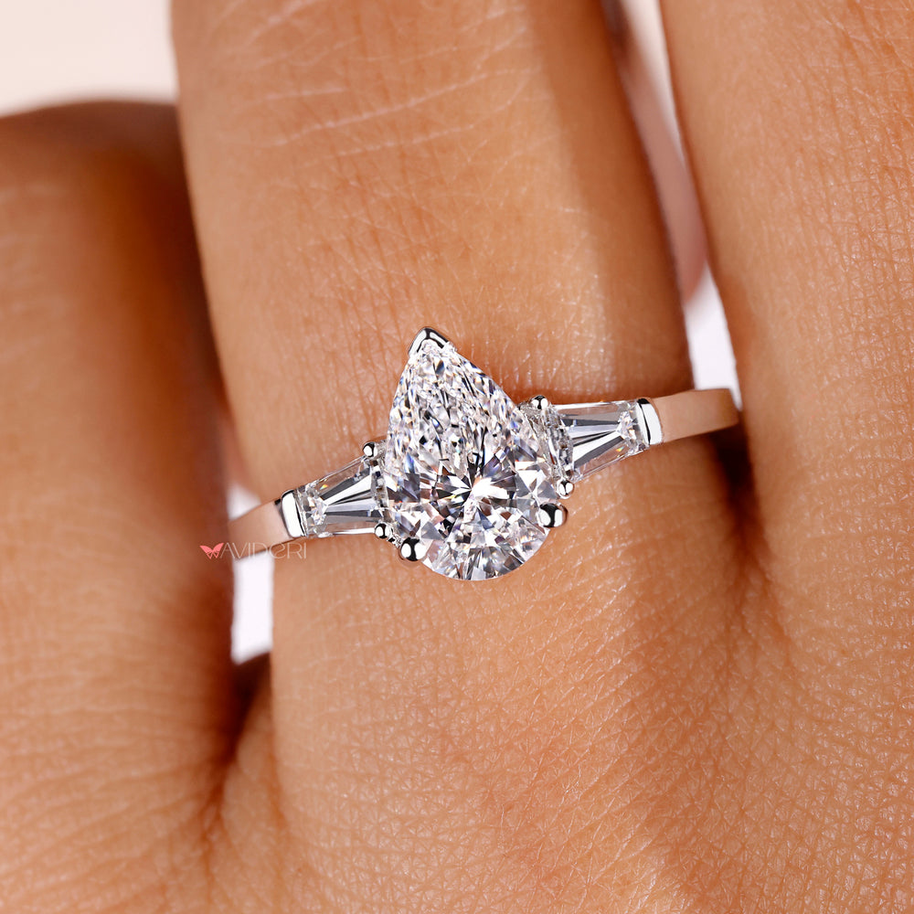2 Tapered Baguette side stone ring enhancing the beauty of the pear-shaped diamond for a luxurious finish.
