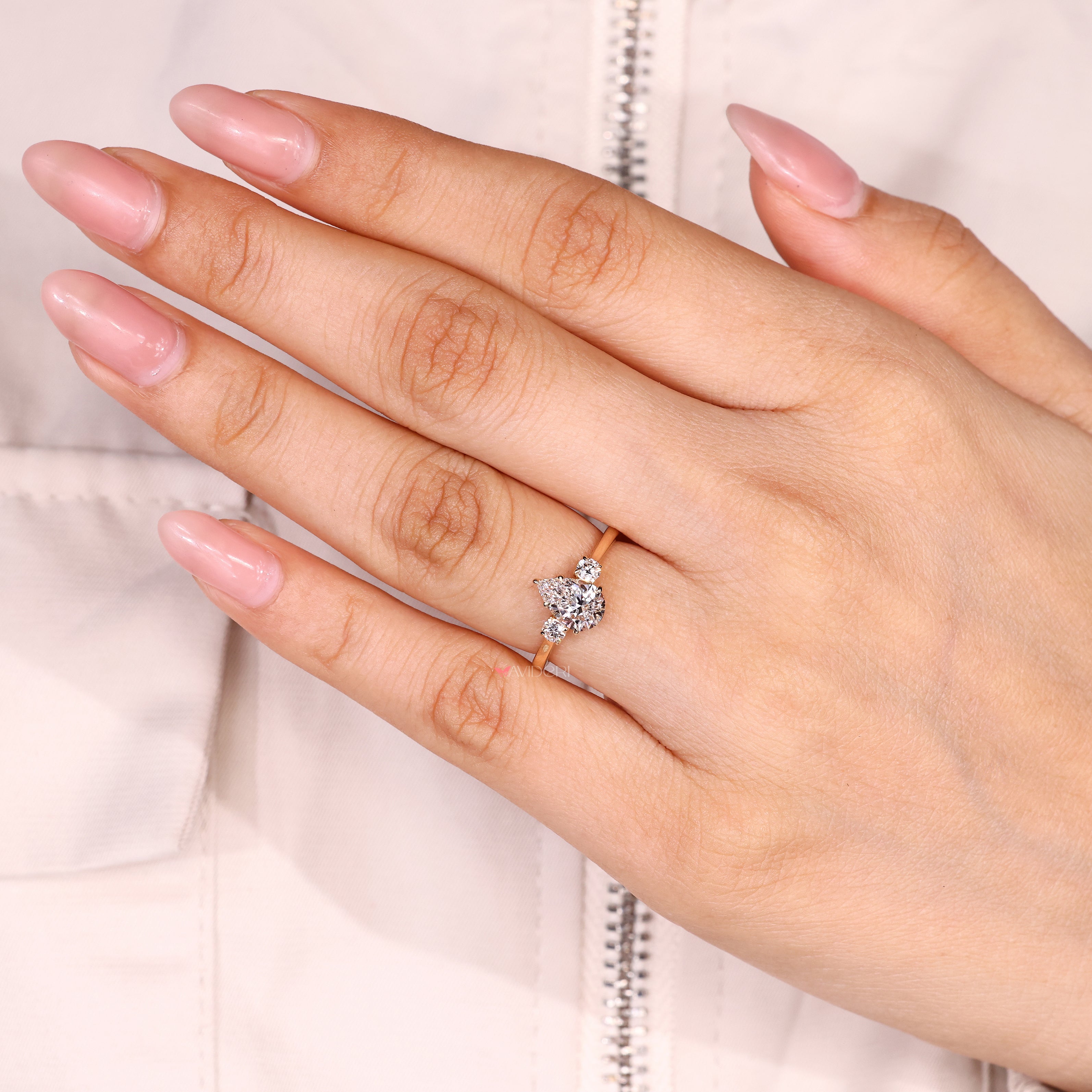 Pear shaped diamond ring with round side stone accents

