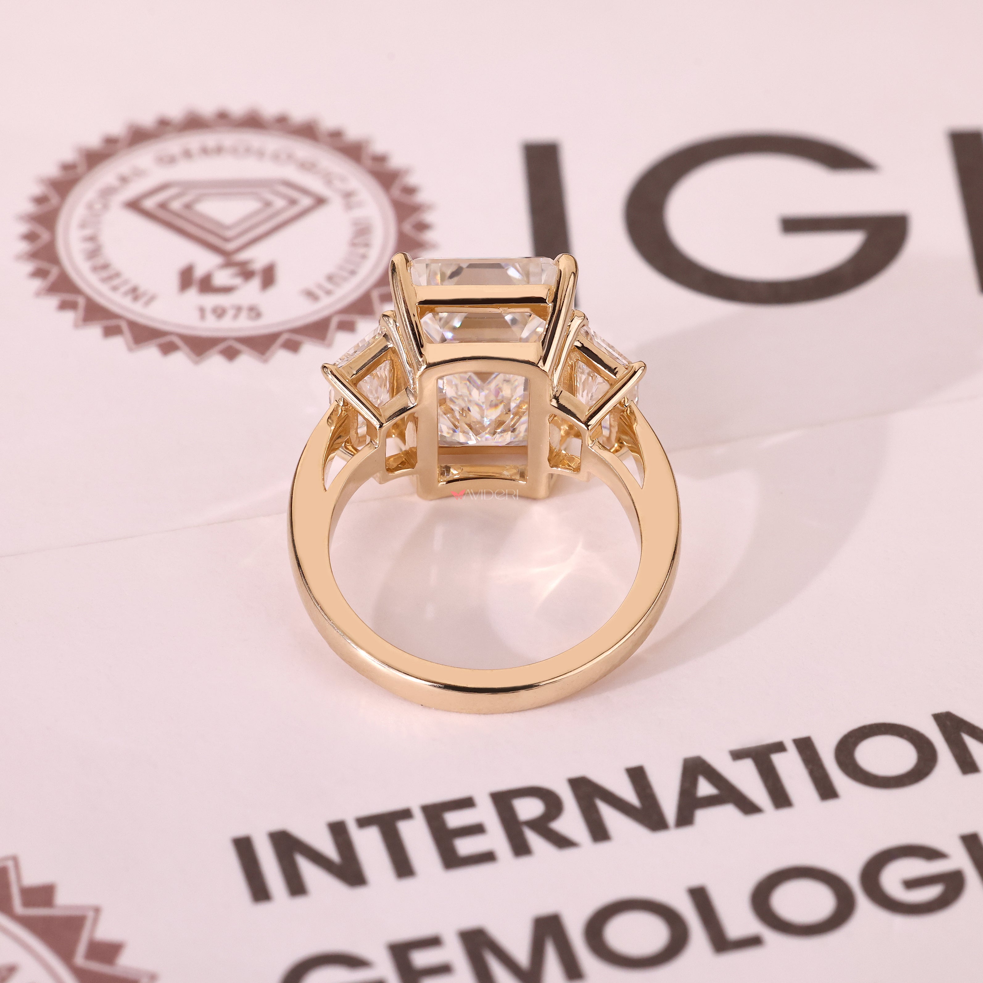 Emerald diamond ring with three stone and basket design
