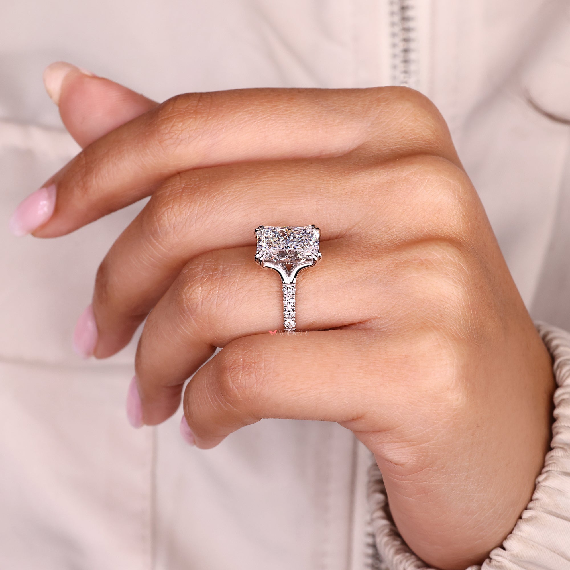 Radiant cut diamond ring with double claw prong setting.
