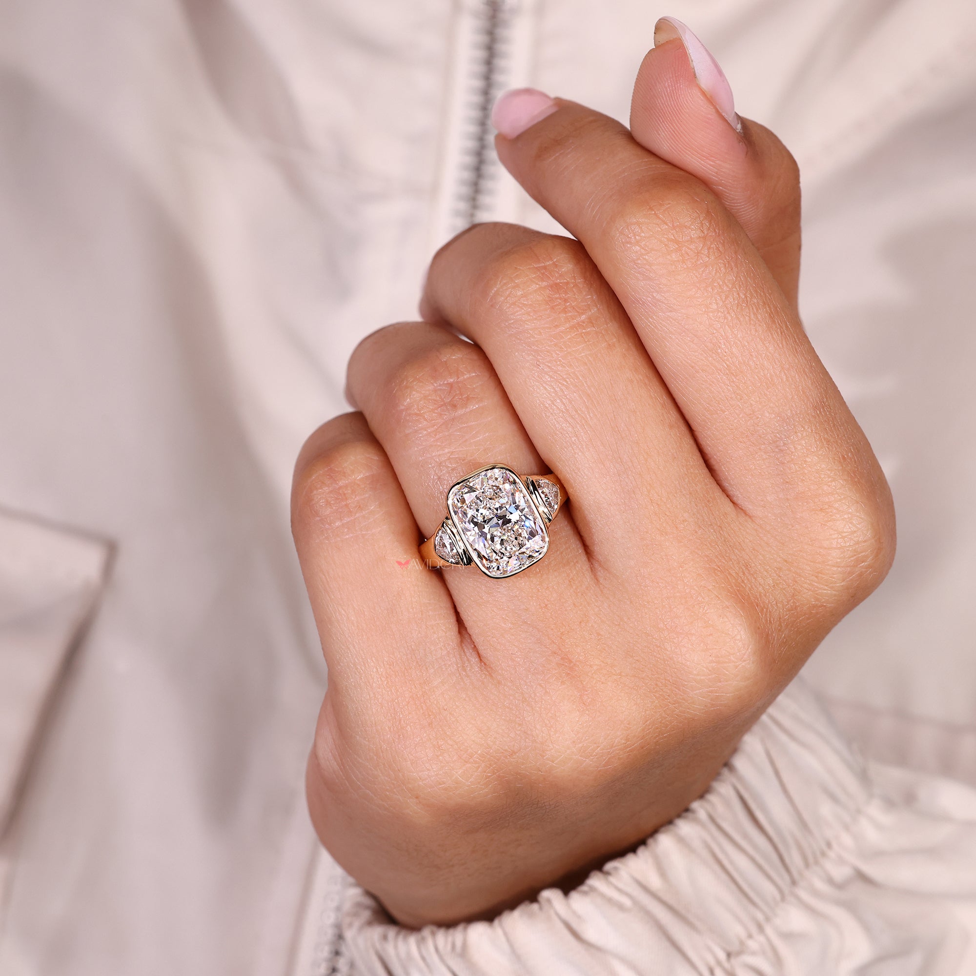 Cushion cut engagement ring with bezel setting style.